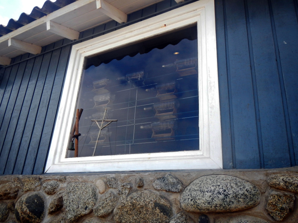 Window with boats in bottles, from the outside.